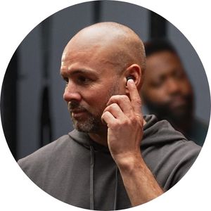 man touching the hearing aid in his ear