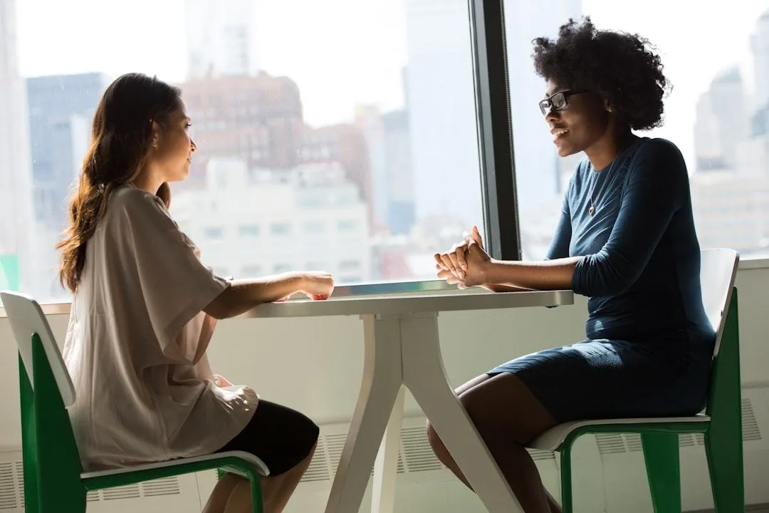 Two people sitting across a table talking