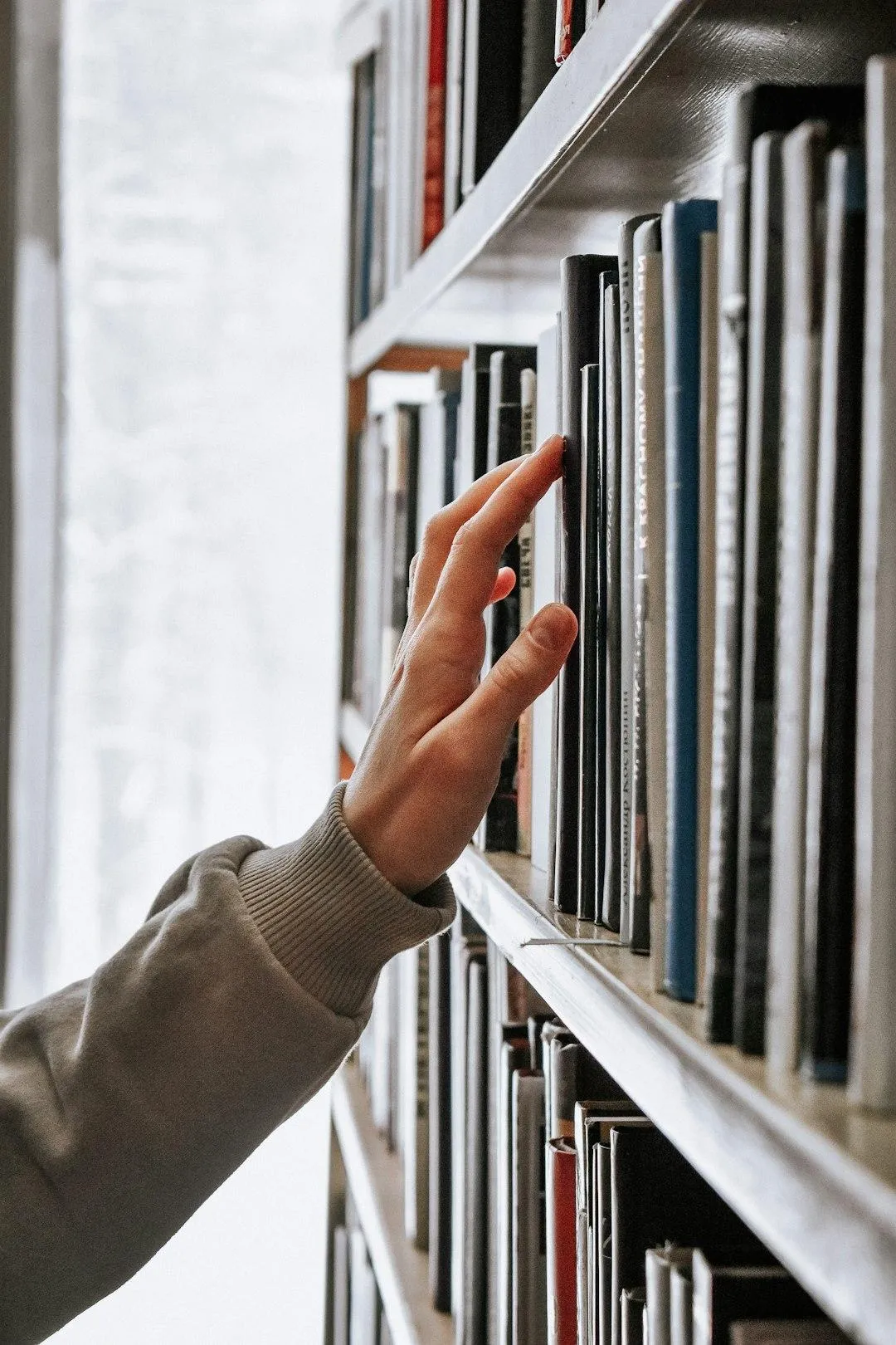 Photo of a hand reaching for books