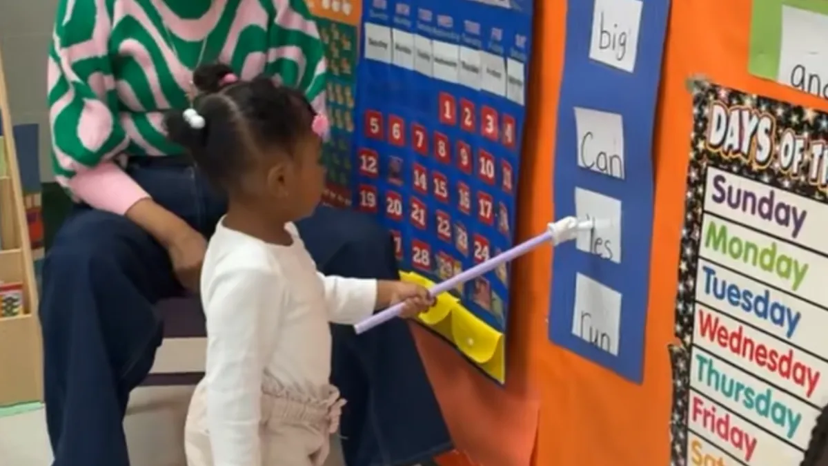 Kids moving with the teacher on a large screen TV