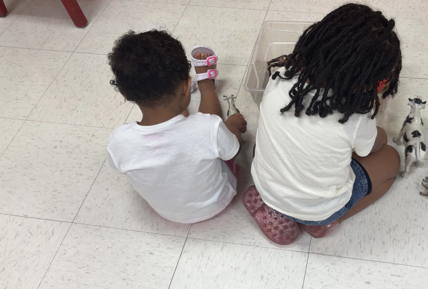 Boy sits on the kitchen counter watching the teacher on his tablet.