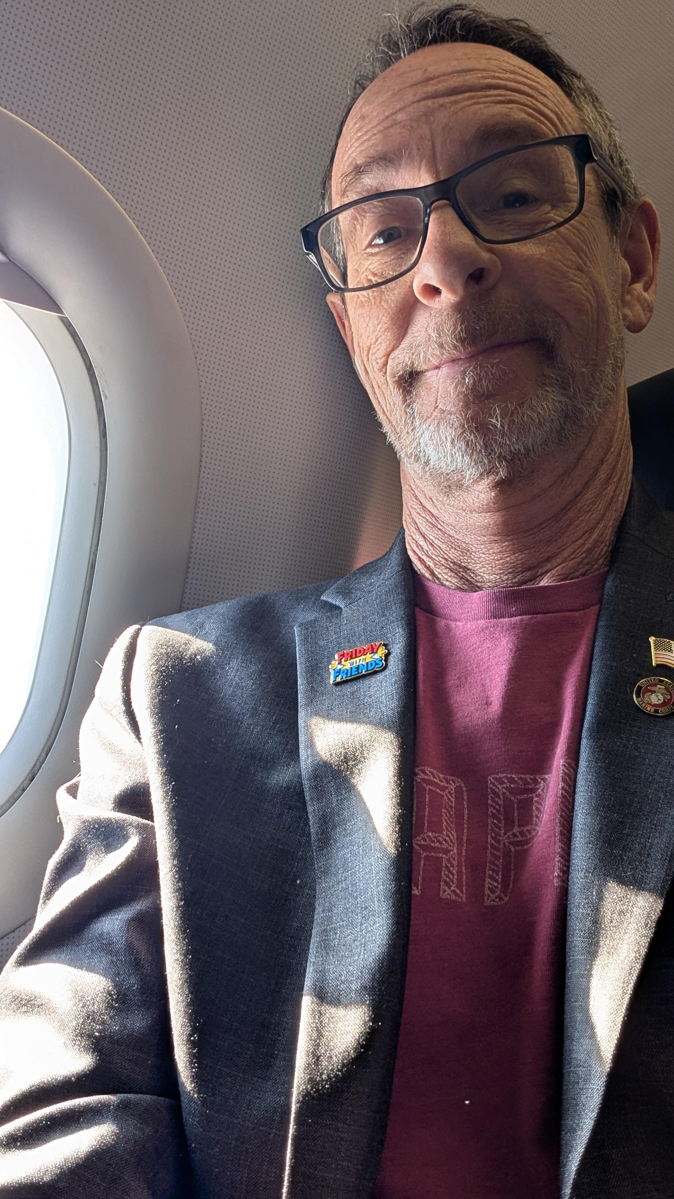 Robin C. Stern on airplane in suit jacket with flag and marine corps pins