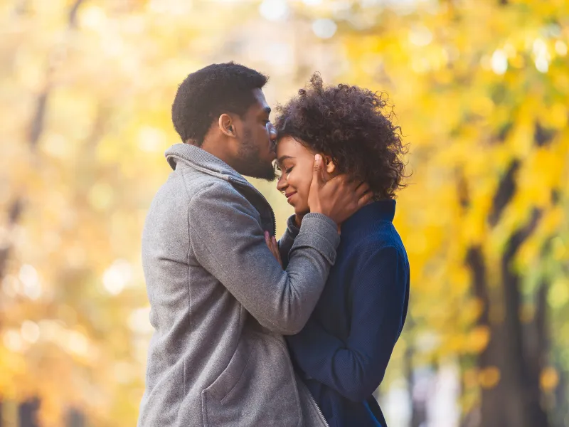 young couple having a quiet moment in the park on a fall day