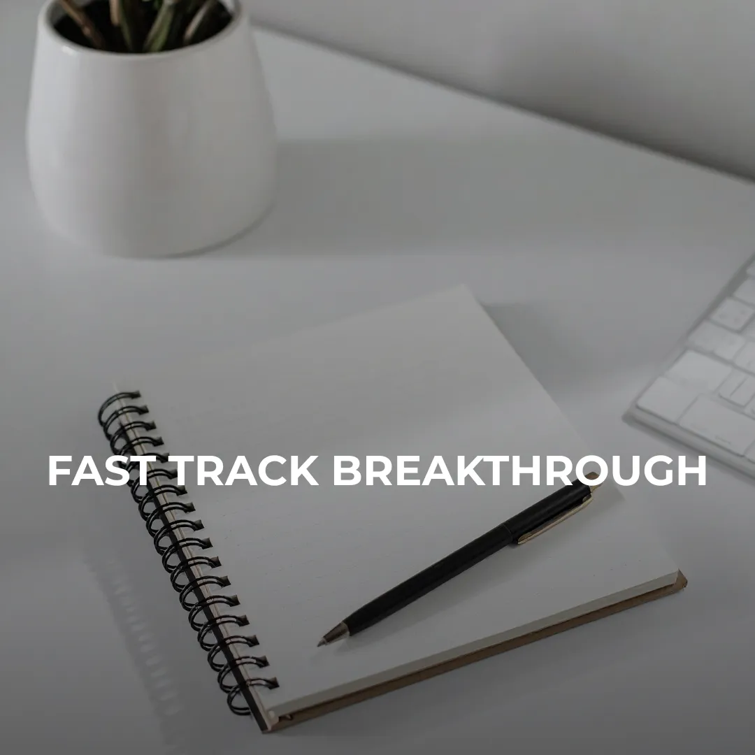 a desk with an open notebook and pen