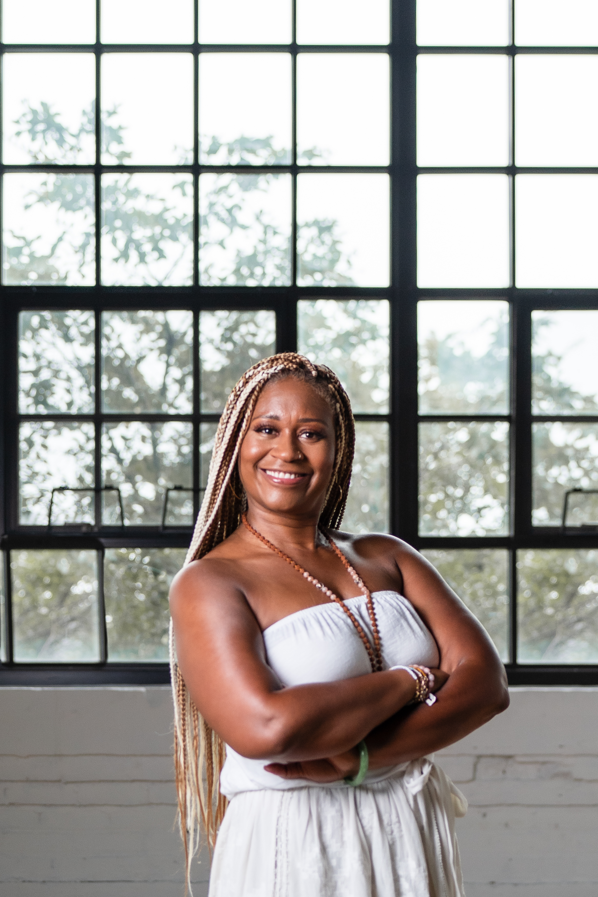 Dawn M. Rivers standing with arms folding in front of a window