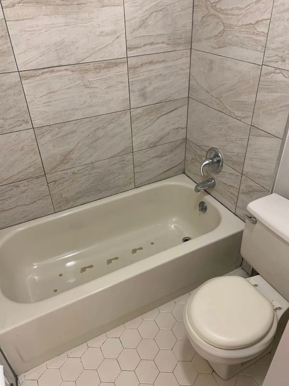 Bathtub with gray tile surround scrubbed shiny during a deep cleaning by Pretty in Pink Cleaning Service near Montgomery, AL