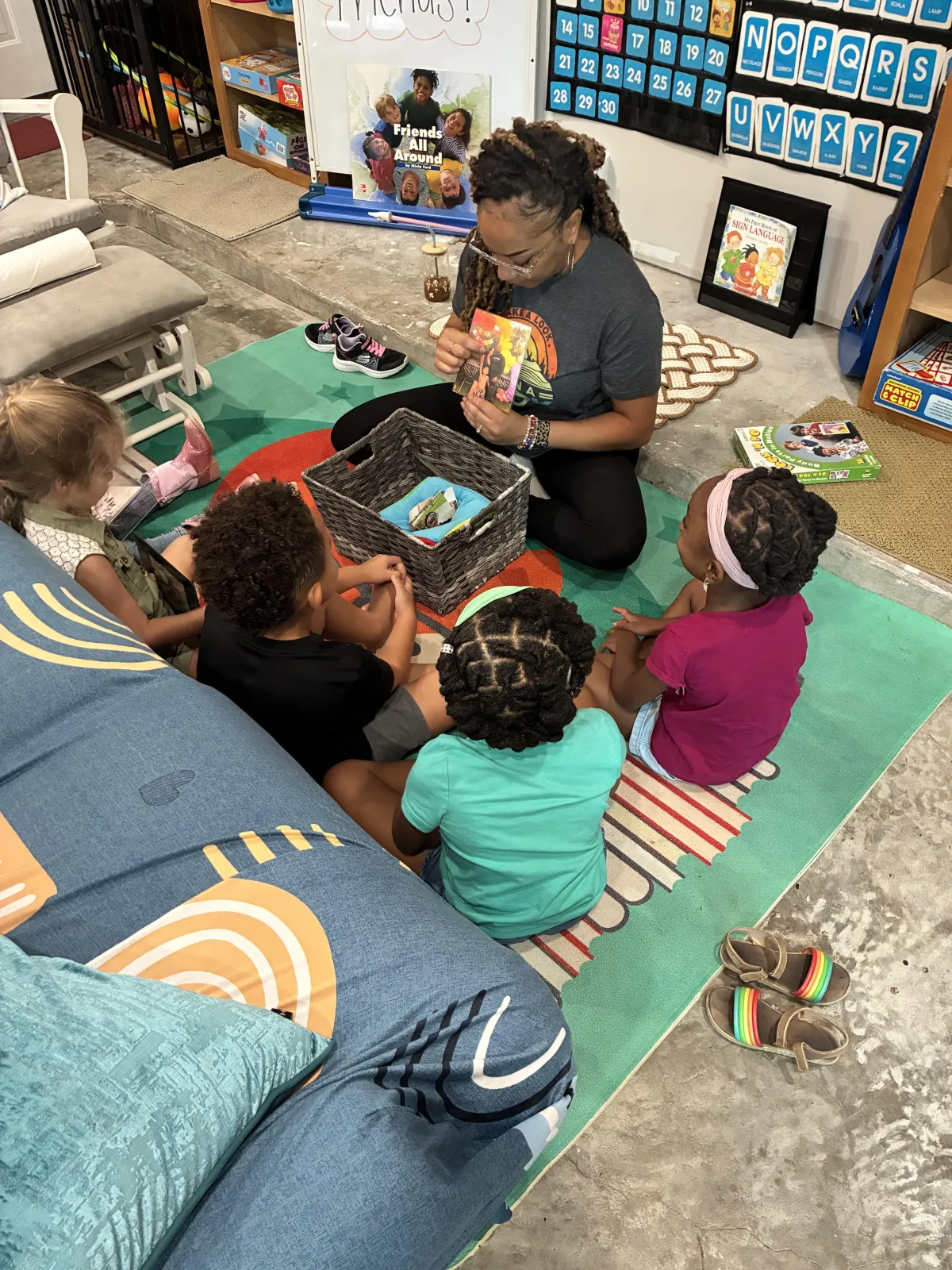 Child writes A in green sand