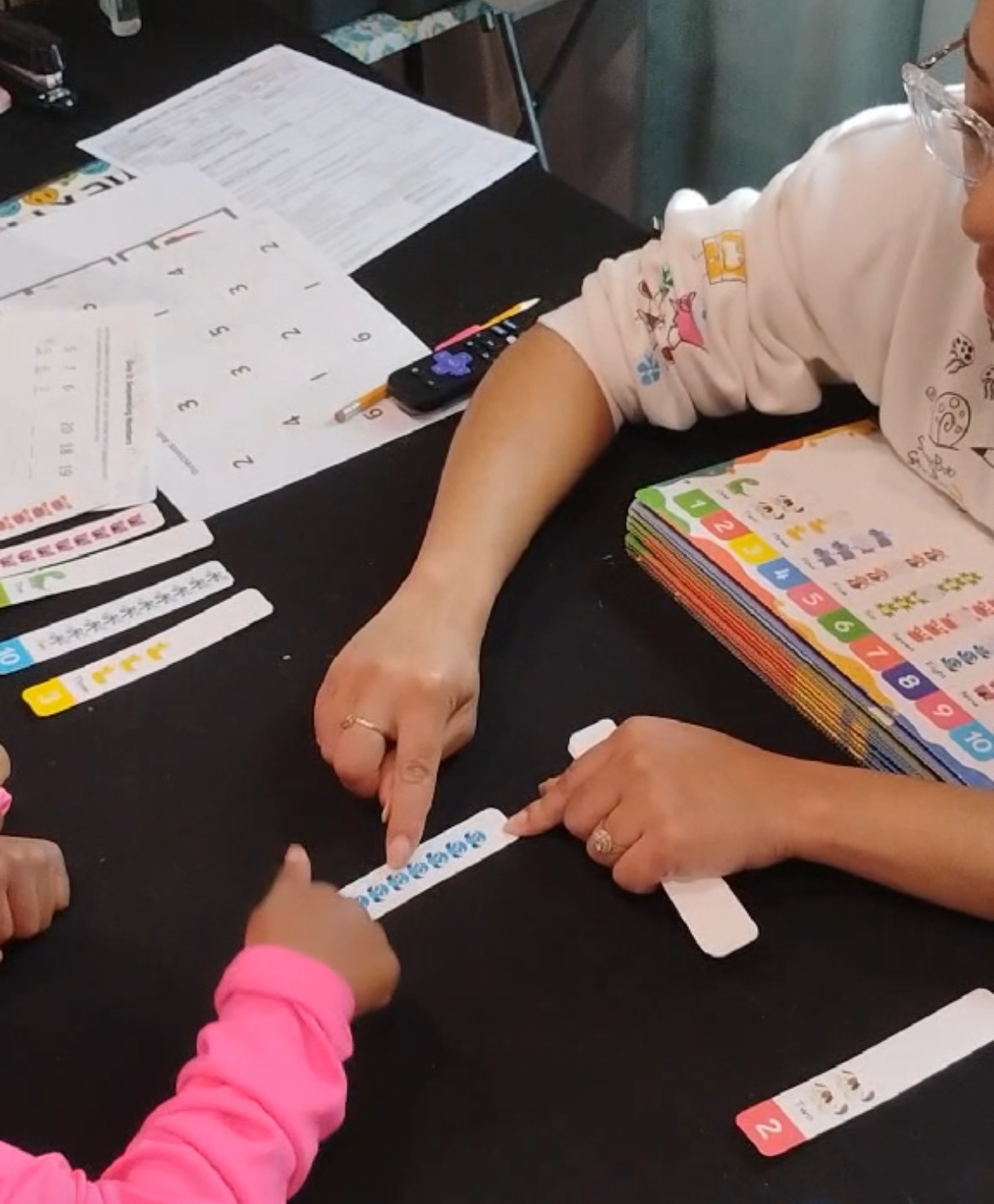Girl stretches to the side while watching teacher on large screen TV