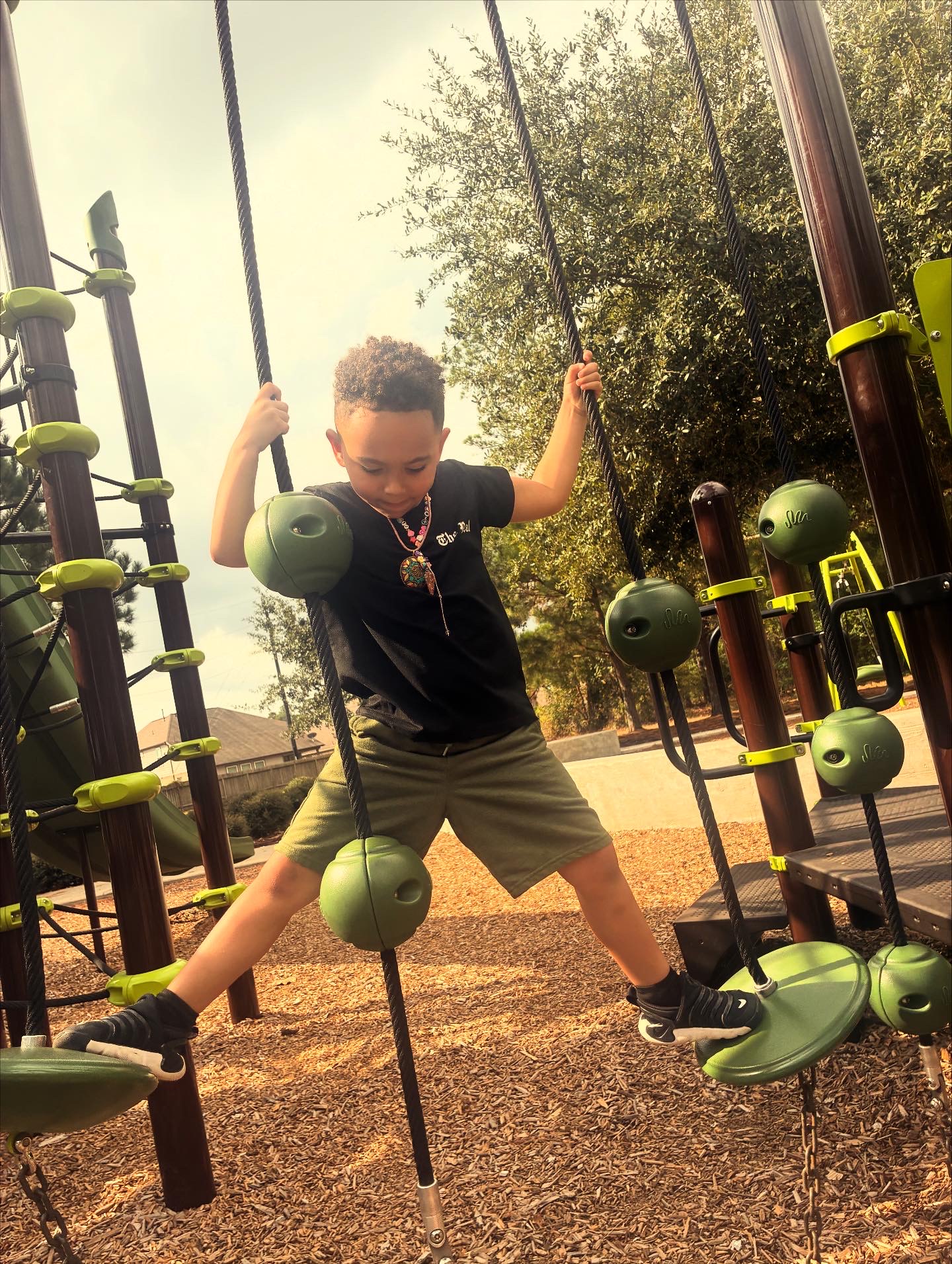 Child with headset smiles as he engages with laptop