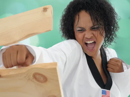 Woman using karate to break boards