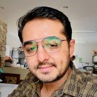 four people watching on white MacBook on top of glass-top table