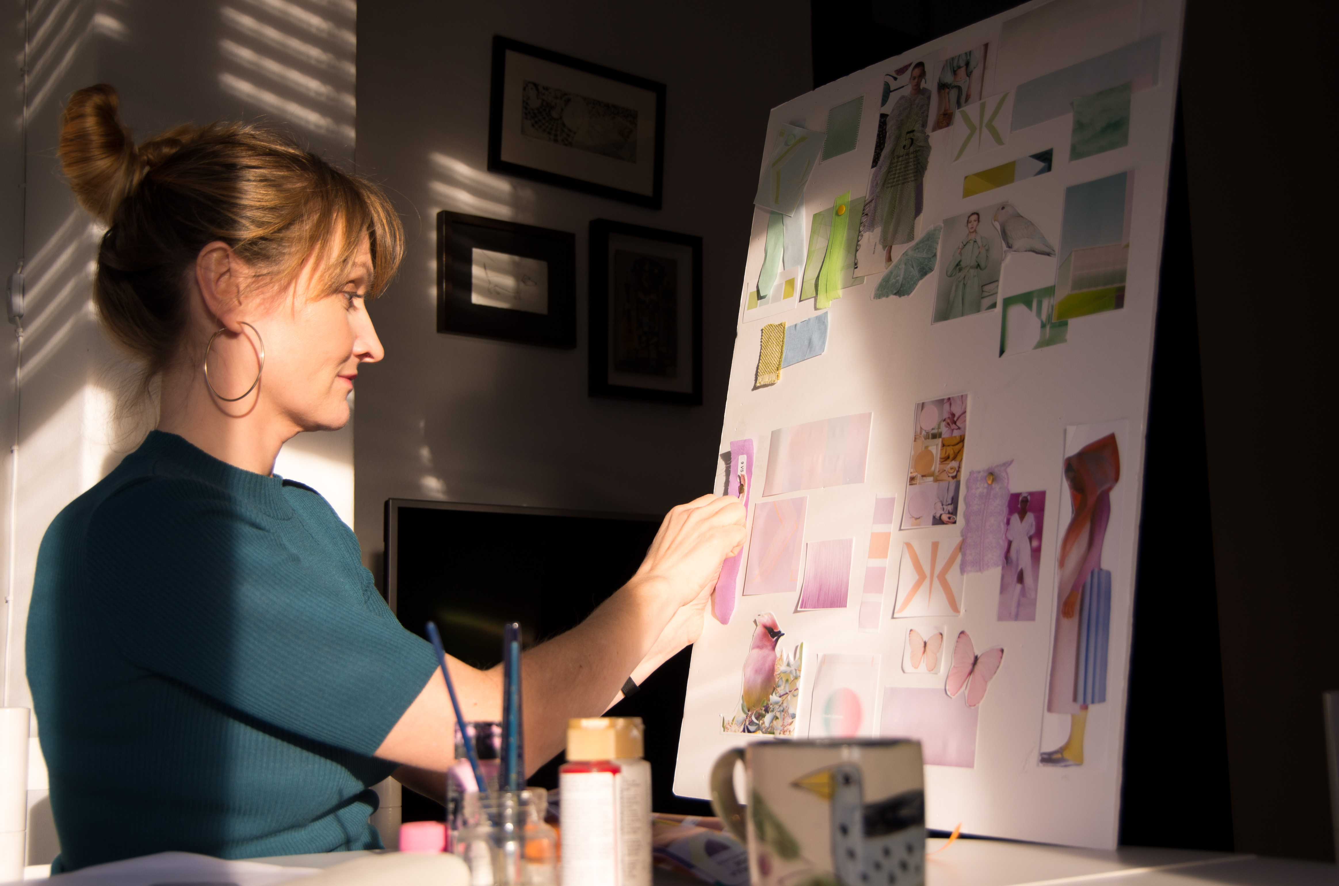 an artist working on her moodboard for her new fan's collection
