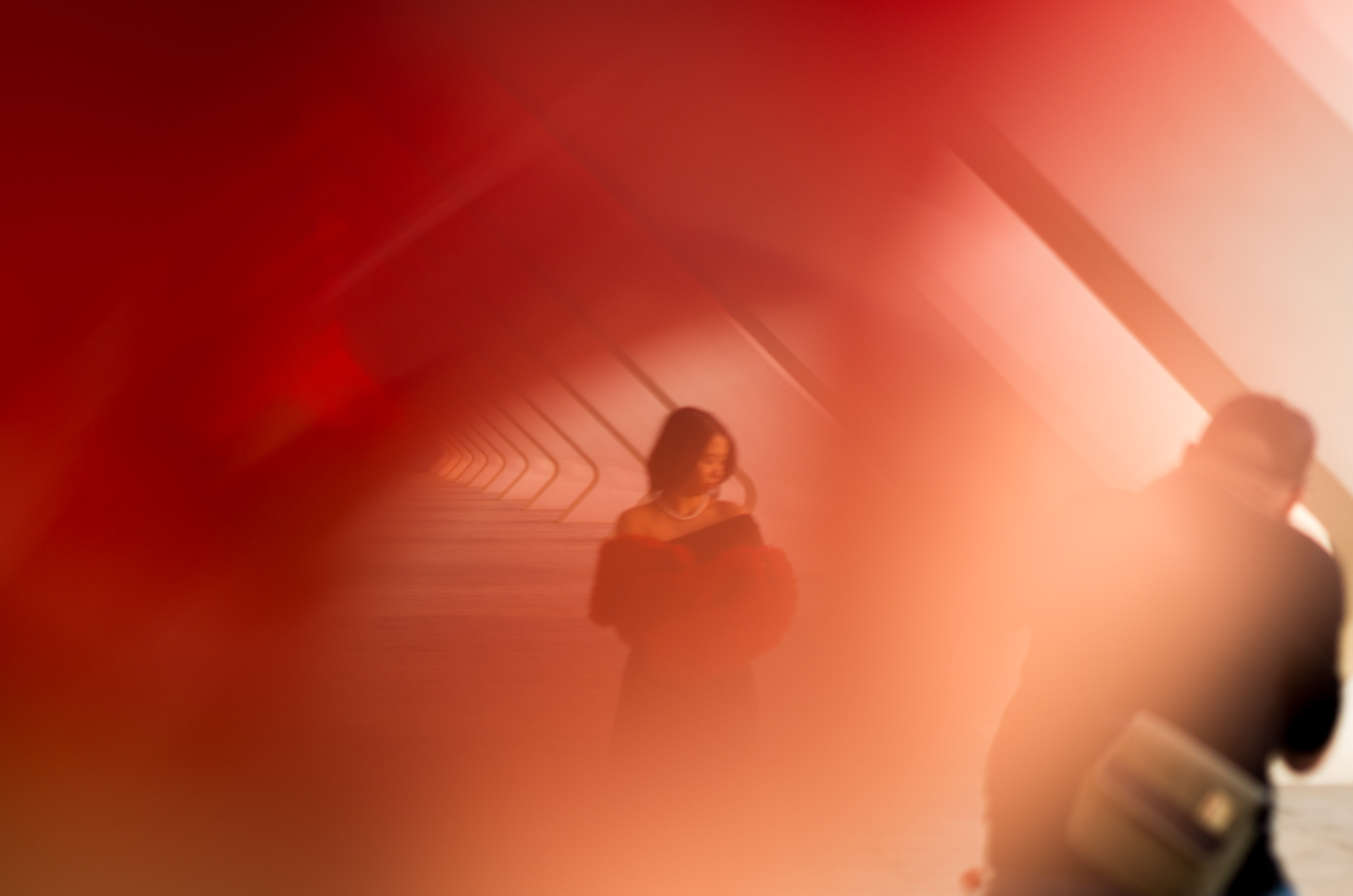 Artistic photography with red light effect capturing a photographer taking photos of a model during a creative workshop at the City of Arts and Sciences in Valencia