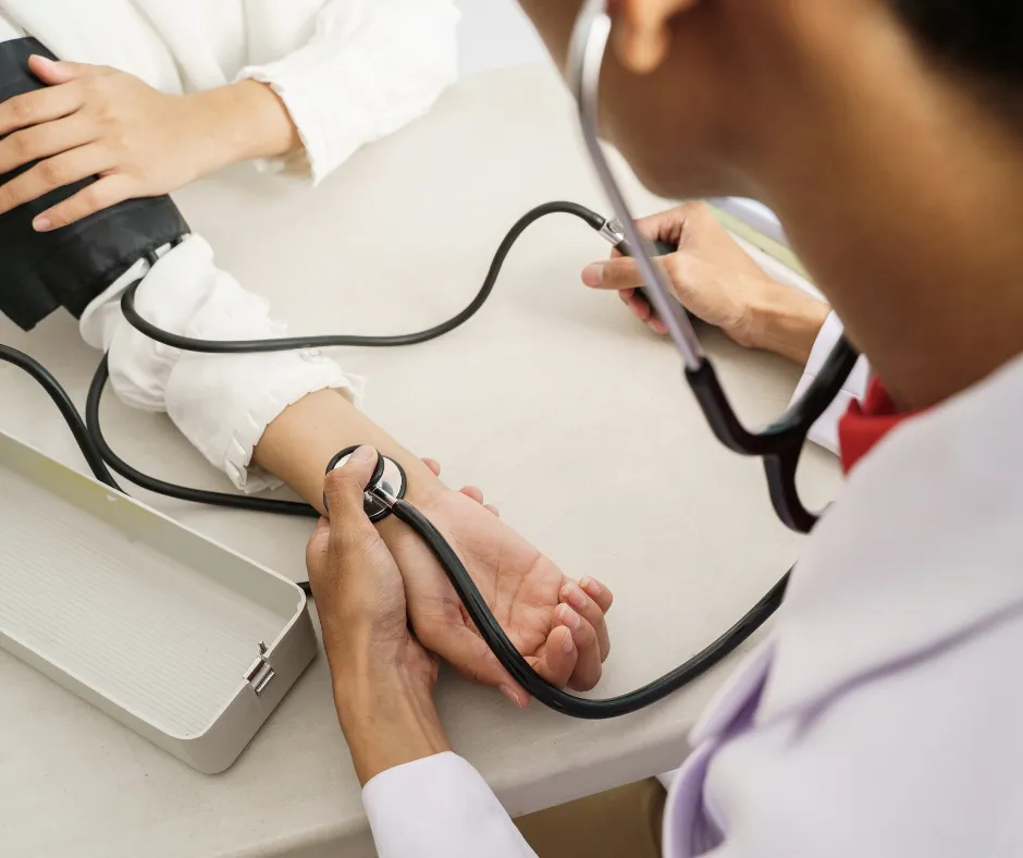 Healthcare provider measuring a patient's blood pressure using a sphygmomanometer.