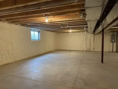 Open basement with foundation walls fully encapsulated in spray foam by Perth Amboy Spray Foam Insulation