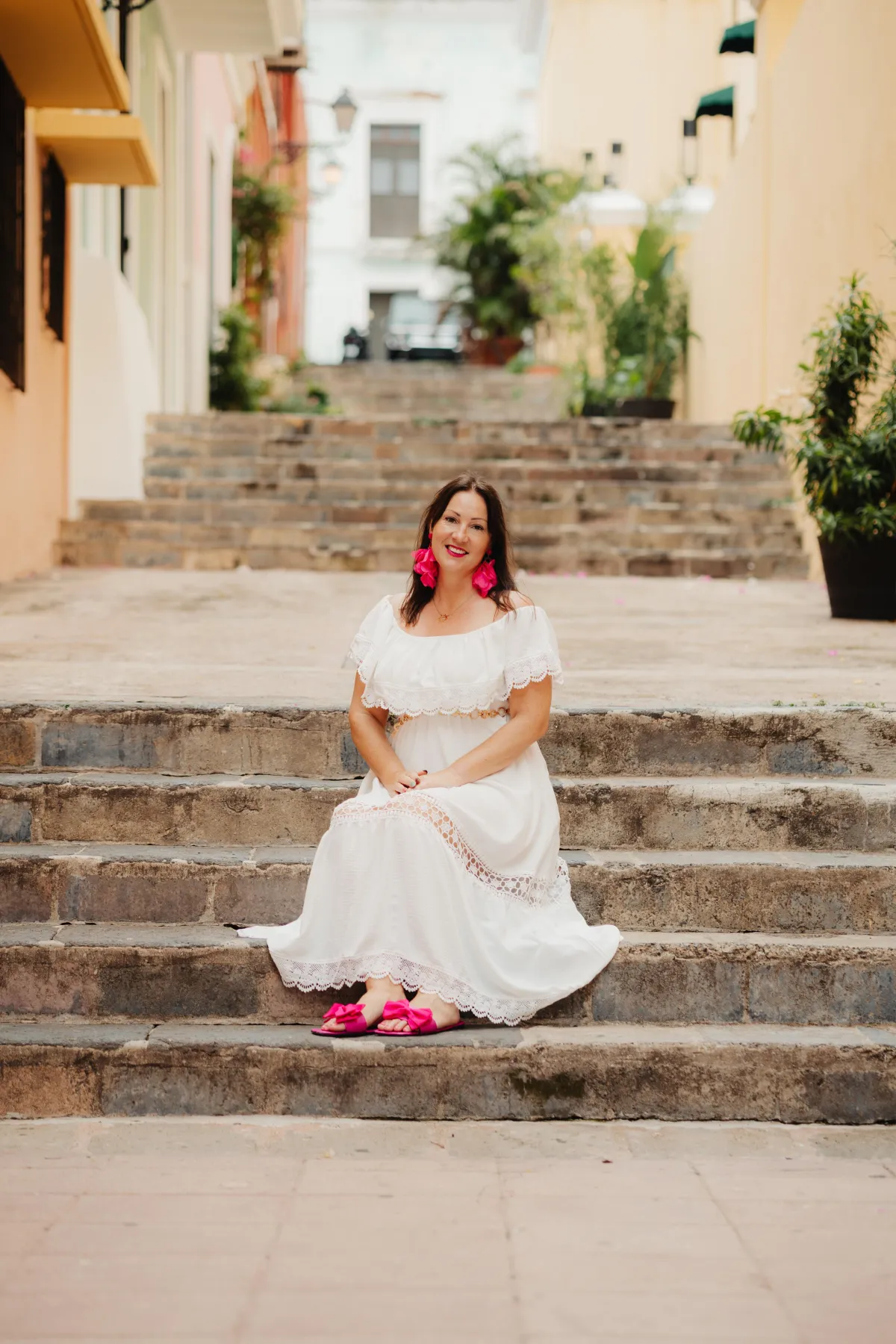 Naomi Morgan sitting on stone steps in a white dress
