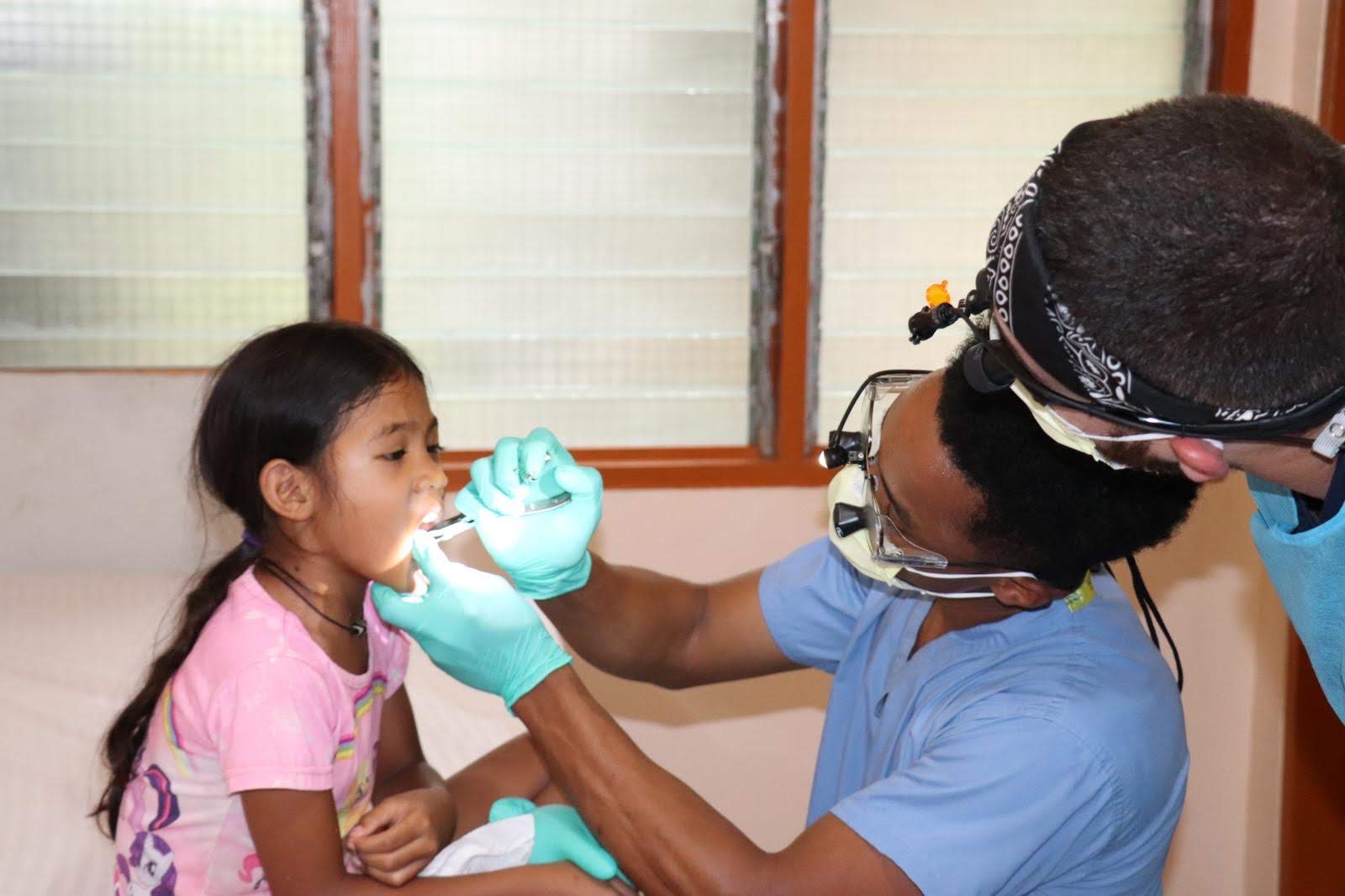 Dr. Wongk performing a tooth extraction on a young patient