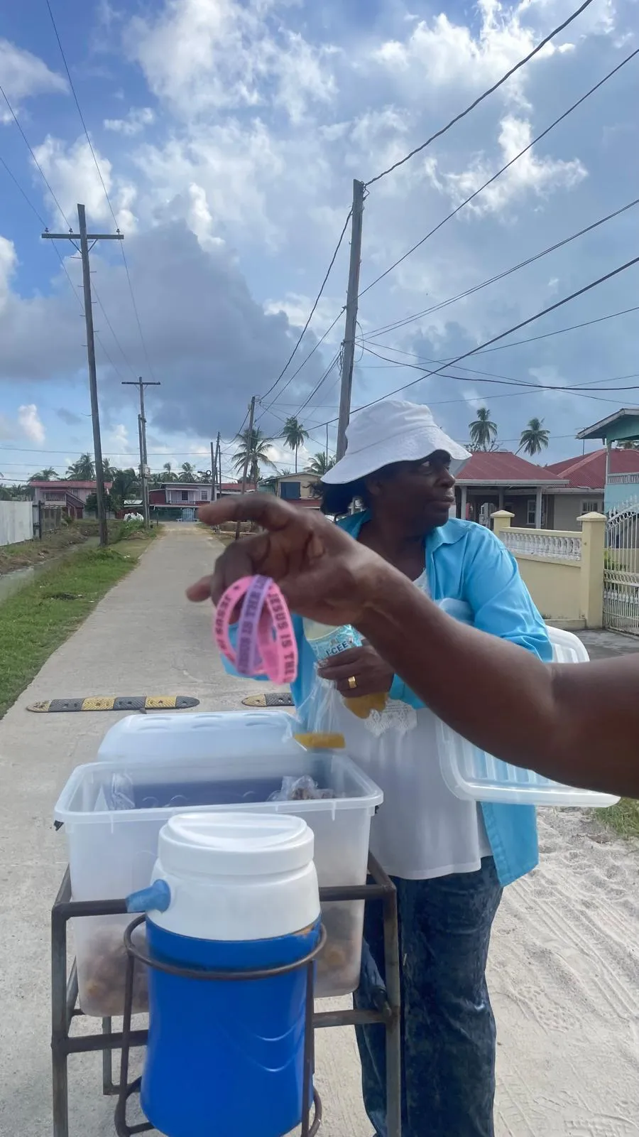 Volunteer handing out wristbands and treats along a Rosignol street