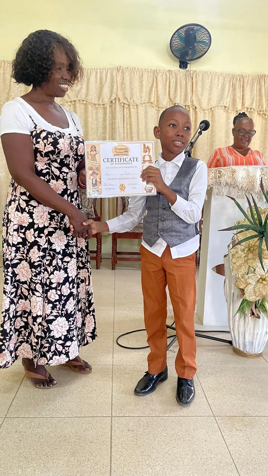 A child receiving a certificate of attendance at the end of the program