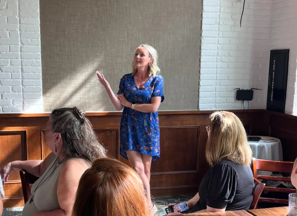 Lindsay Fletcher speaking about Sales Psychology and why it's important to learn how to sell at BloomHER collective. She is wearing a blue dress.