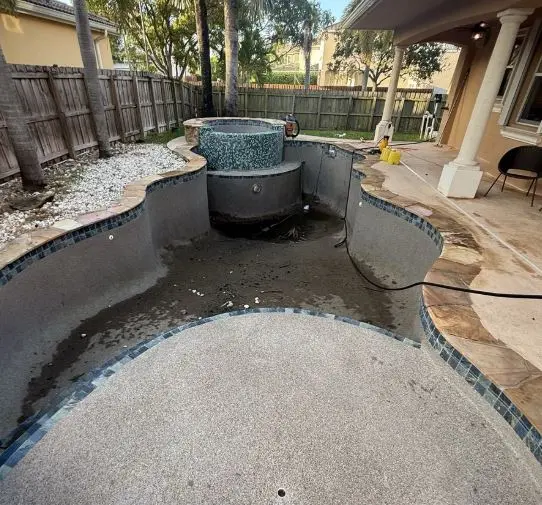Drained freeform pool and attached spa prepped for resurfacing by Lakeside Pool Service