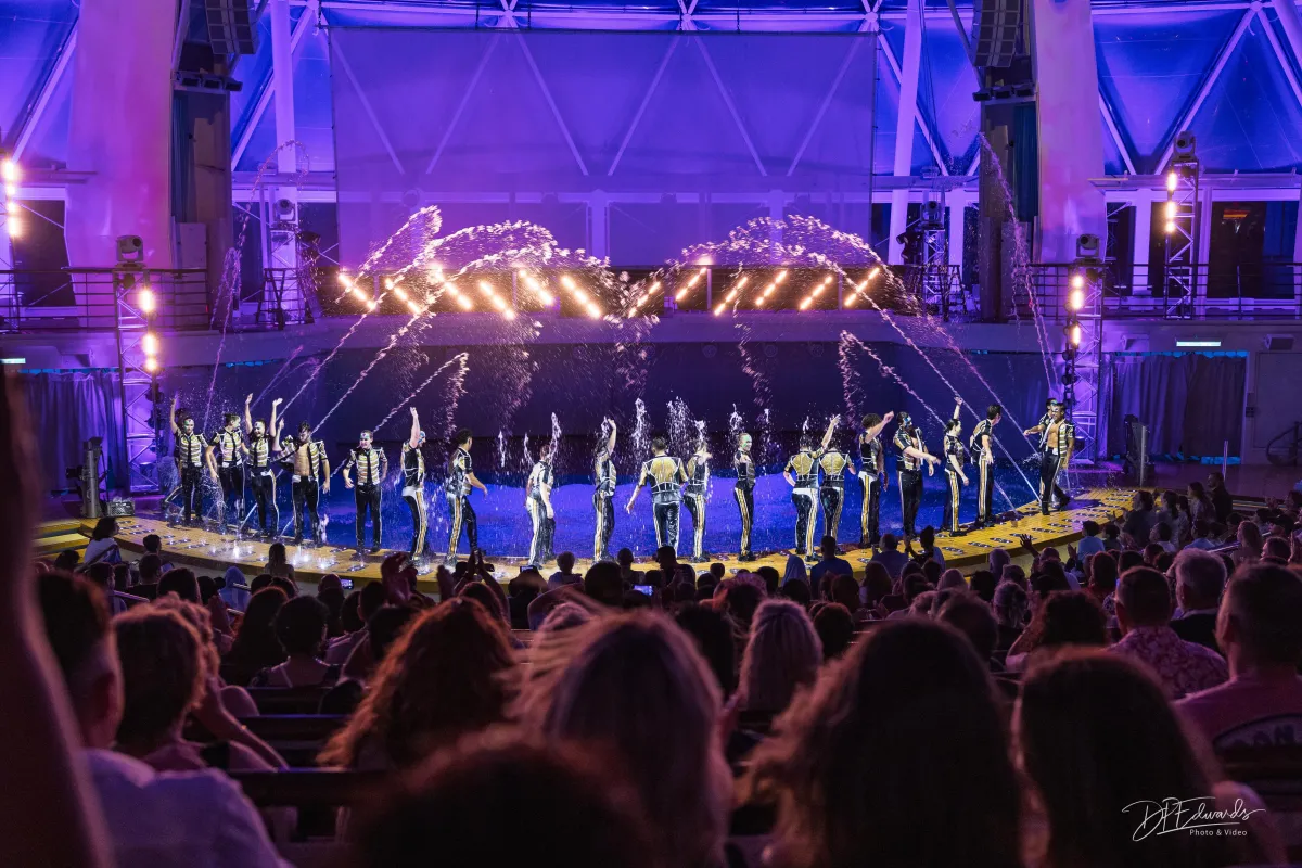 cruise ship water show with dancers, lights and water spouts