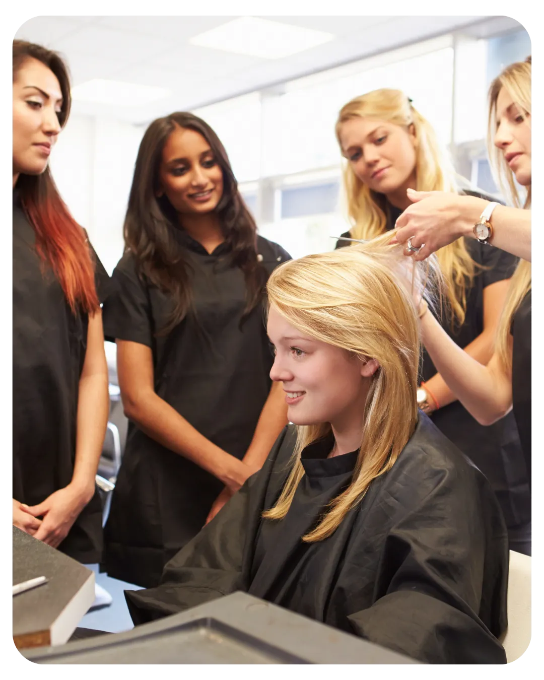 Students learning hairdressing by practicing on a client, representing hands-on training at Miracles Academy