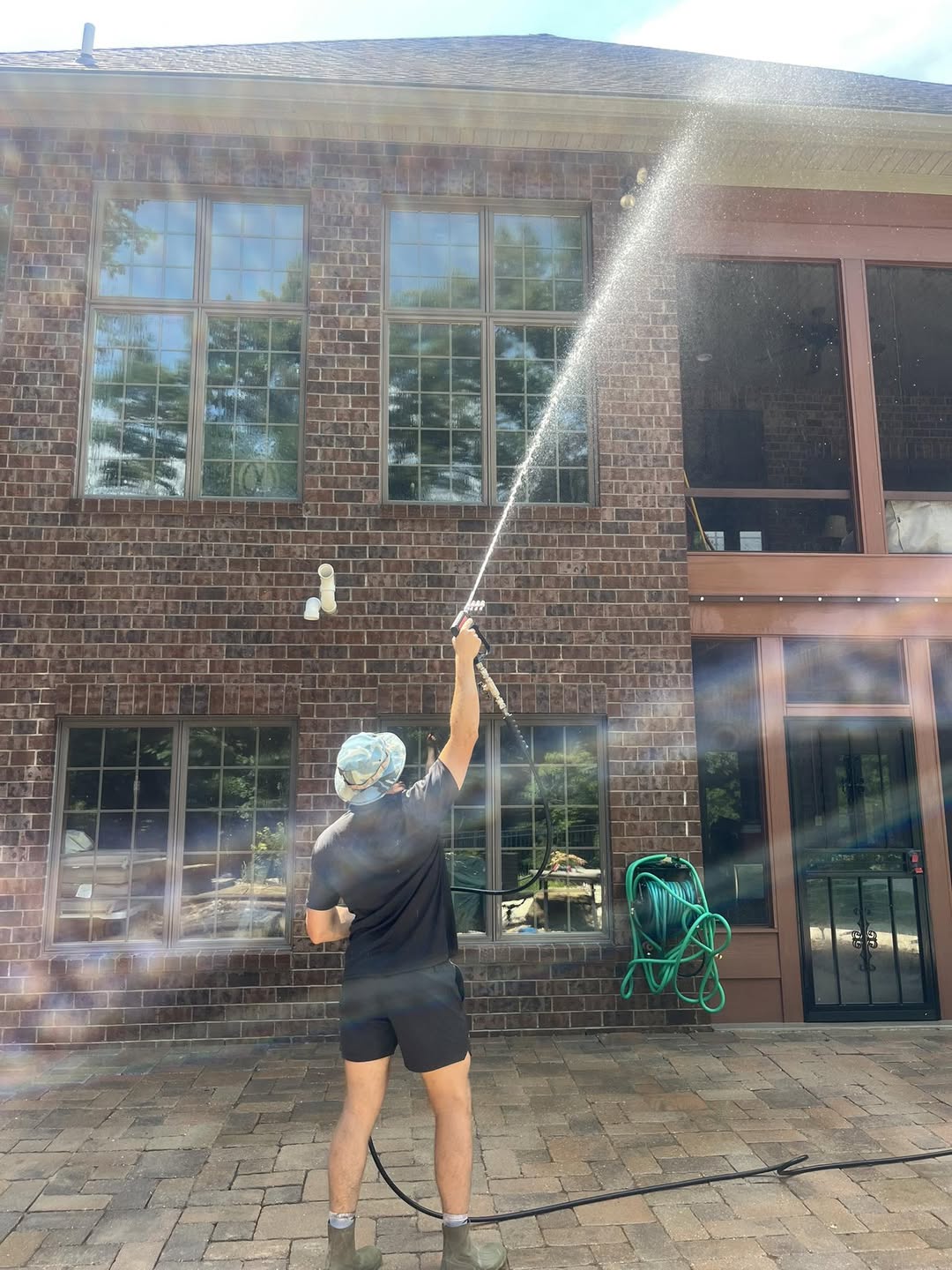 Red Carpet Pro Wash technician pressure washing a brick home in Troy, Illinois