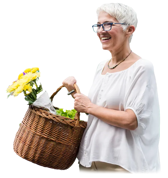 older woman smiling holding basket of flowers