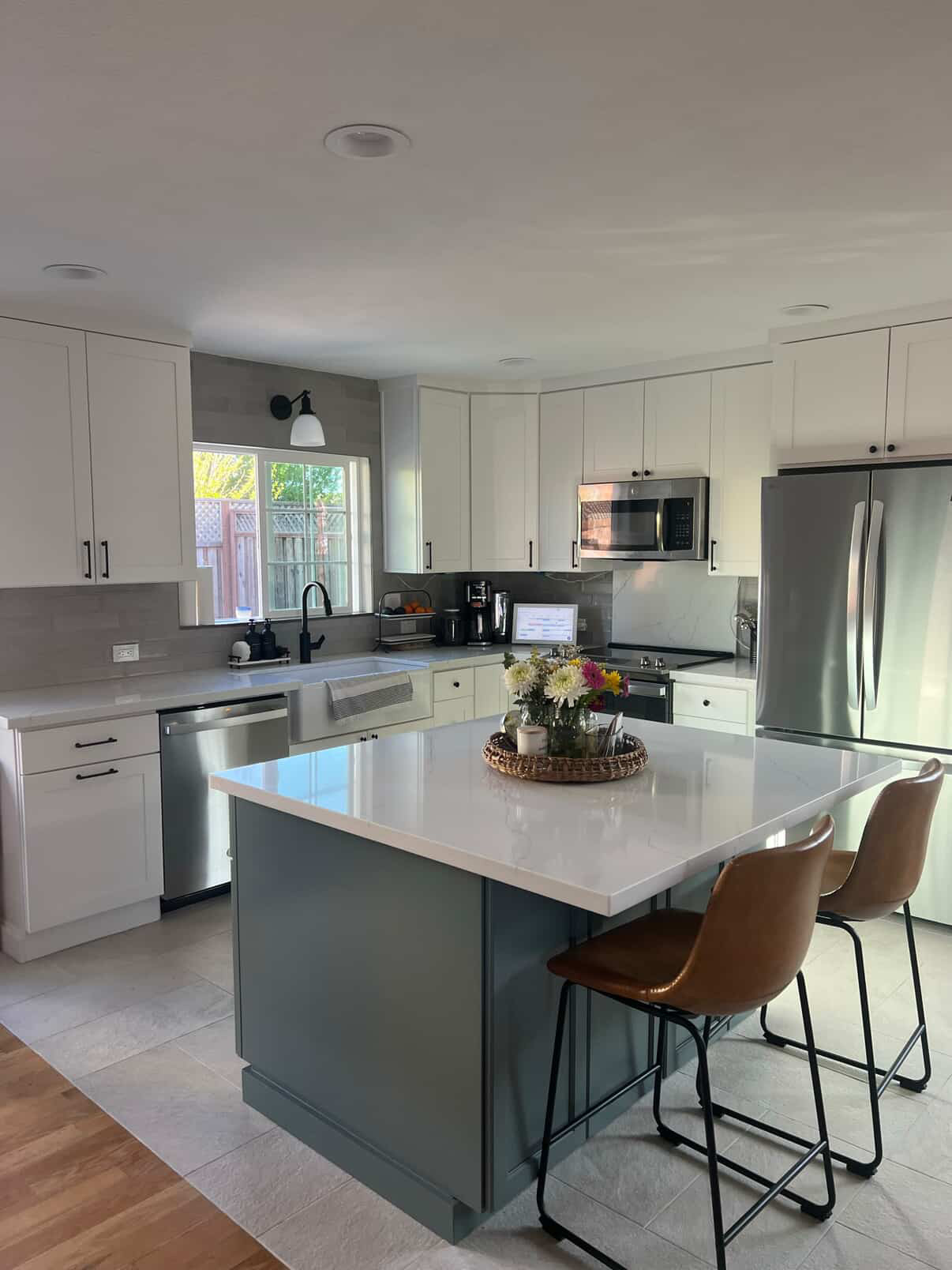 View of a kitchen island with butcher block countertop, pendant lighting, and stove in the background.