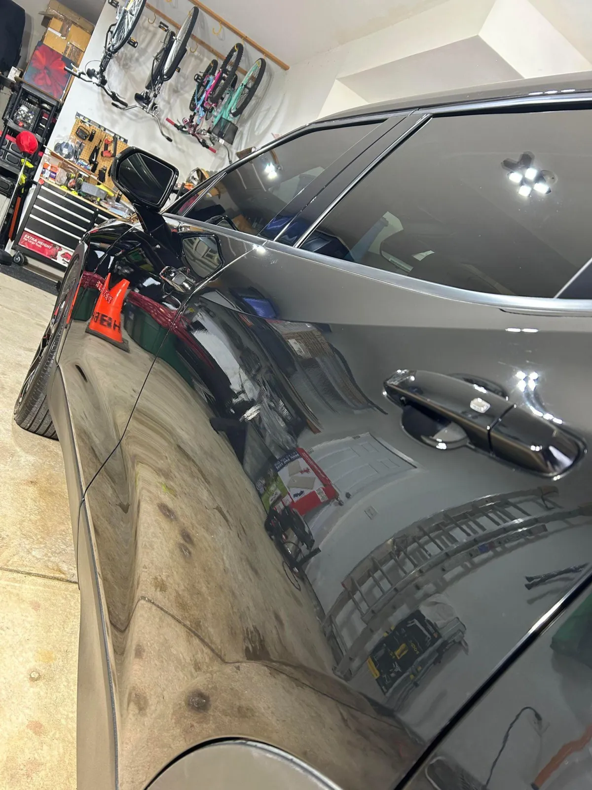 Shiny black car in garage with a ceramic coating applied.