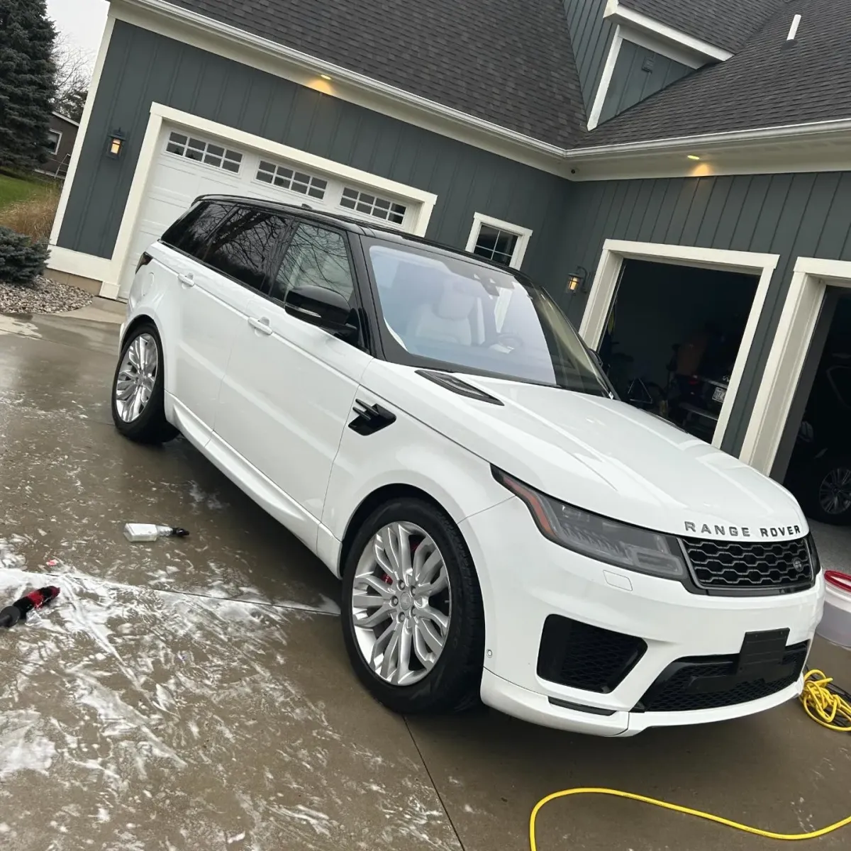 White Range Rover sitting outside in a driveway after being detailed.