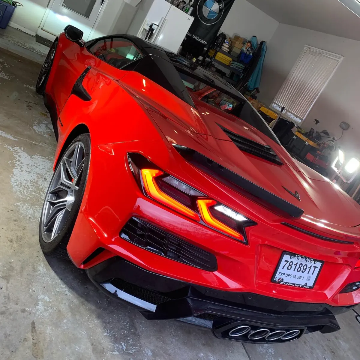 Red C8 corvette sitting in a garage after a 10 year ceramic coating was applied.