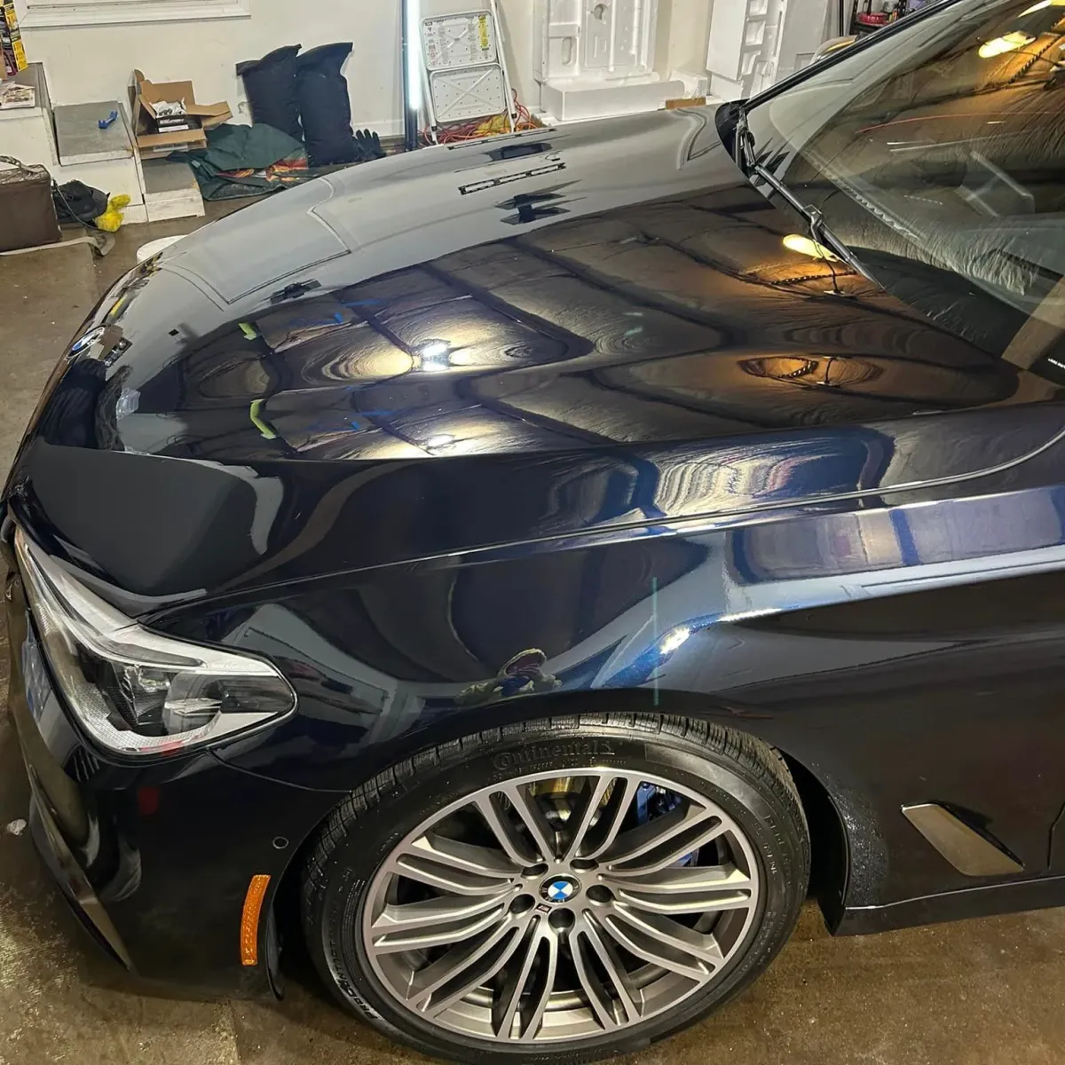 Bmw car parked in a garage under bright lighting after being ceramic coated.