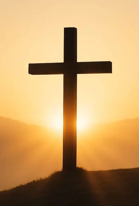 Cross on a hill at sunrise with warm golden light
