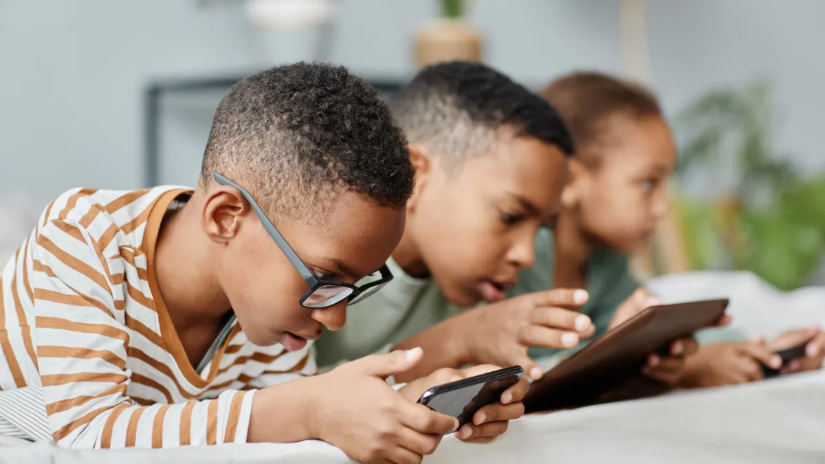 children using tablets with poor posture contributing to tech neck and spinal stress