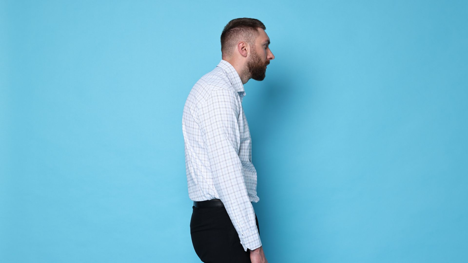 Man demonstrating poor posture with rounded shoulders and forward head posture while standing.