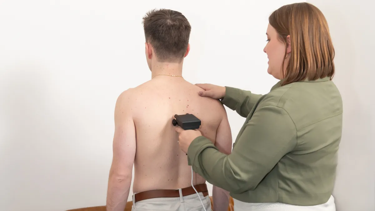 Dr. Kallie Fischer Scanning Man's Back with Gonstead Techinique at Rise Family Chiropractic in O'Fallon, MO