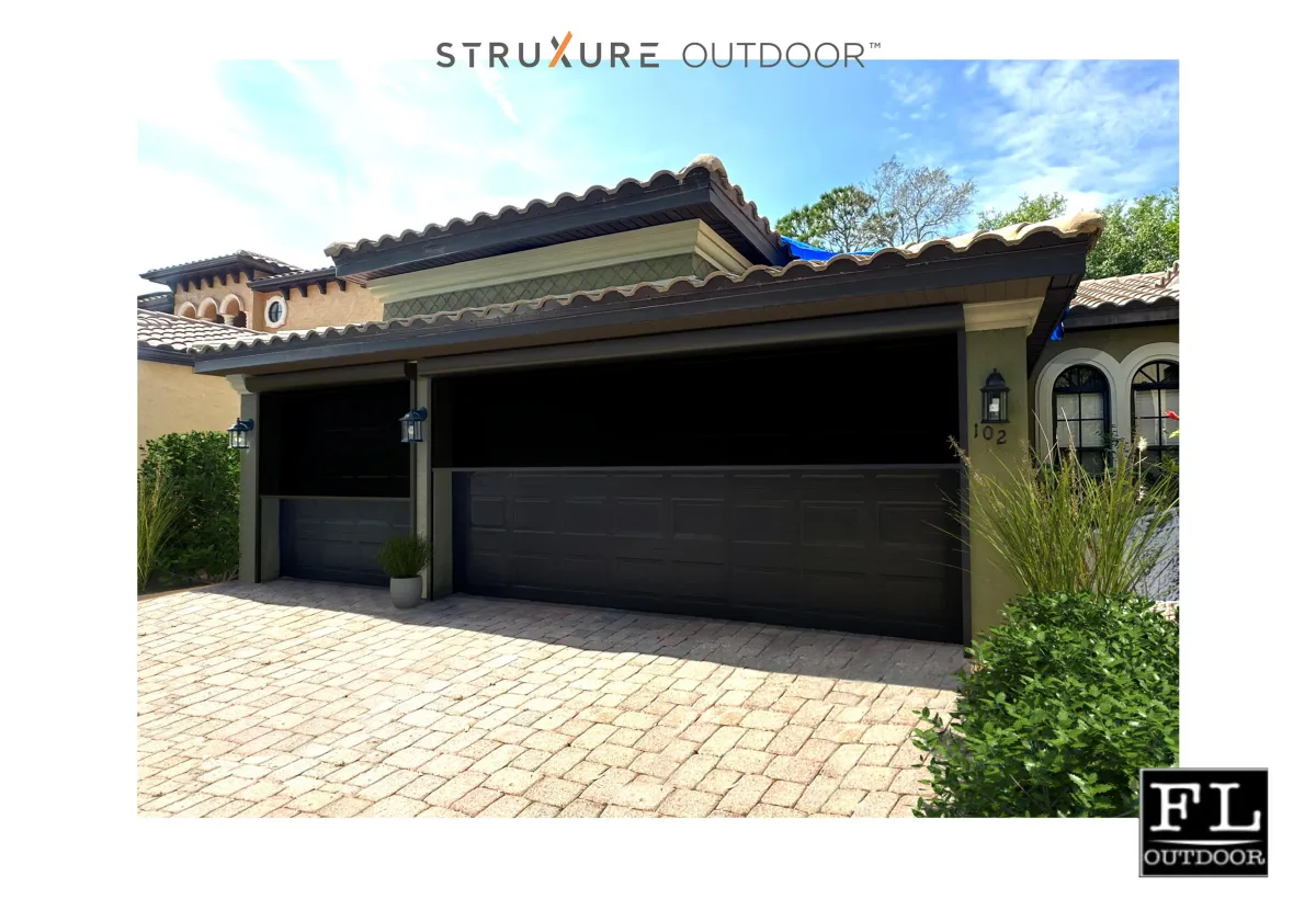 A double garage door with two FL Outdoor Motorized Screens mount on the outside of this spanish style home. 