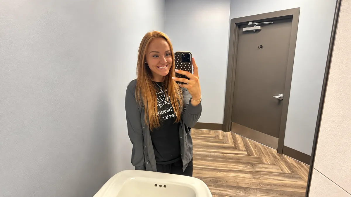 Kylie smiling in a mirror selfie at work
