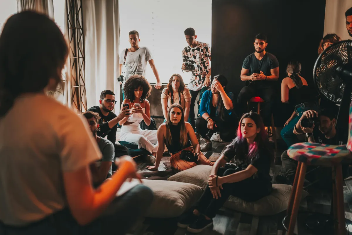 Group of artists gathered together listening to a speaker