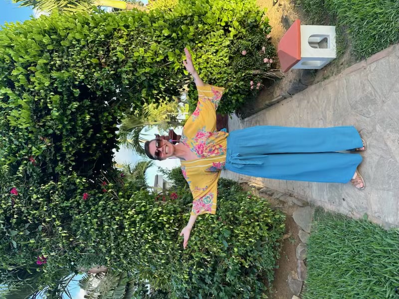 Woman standing outdoors with open arms feeling free, confident, and emotionally open