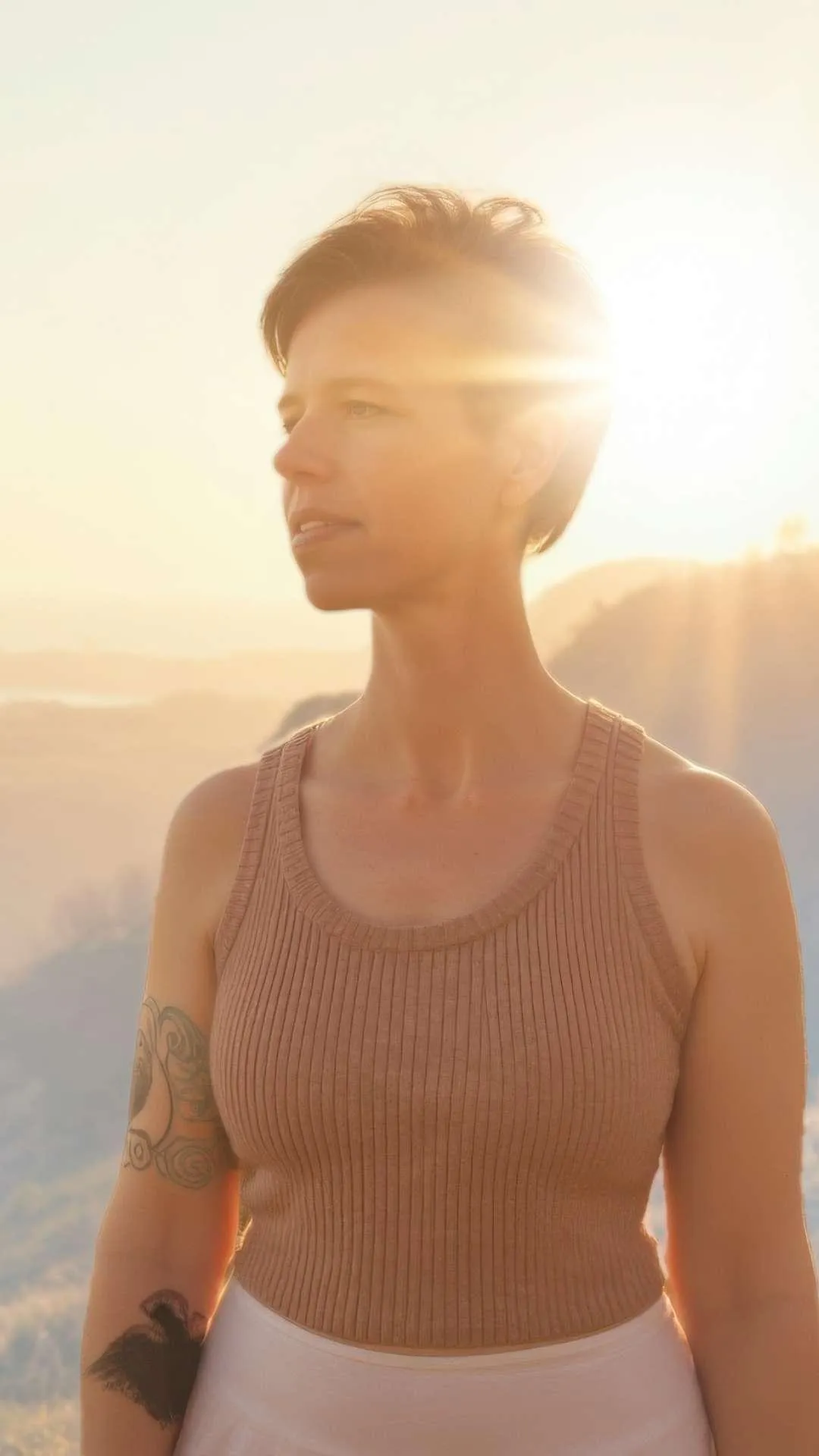 Woman standing in sunlight feeling grounded, confident, and clear, representing clarity, leadership, and inner alignment