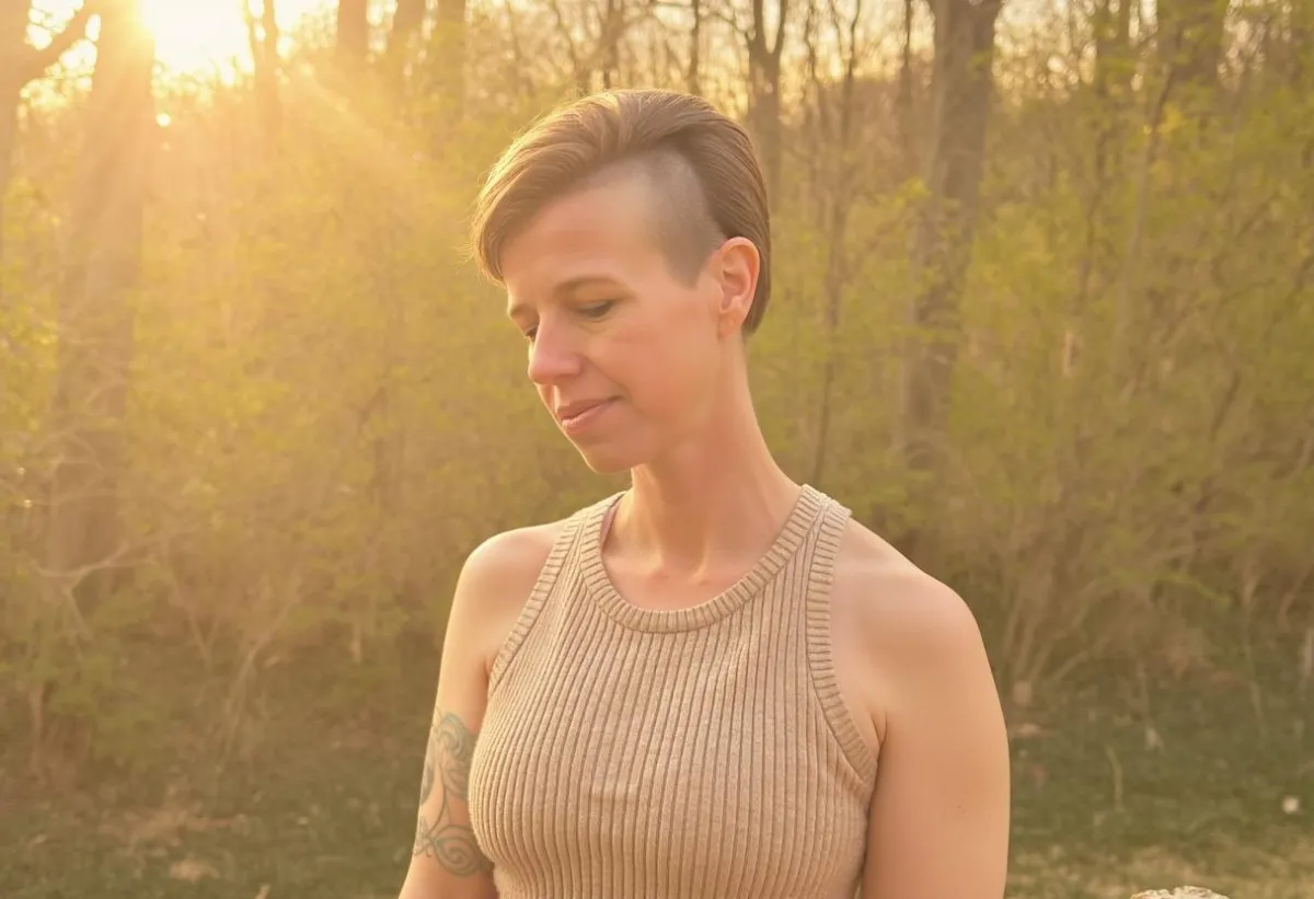 Woman standing in nature feeling calm, grounded, and reflective, representing clarity, integration, and inner peace