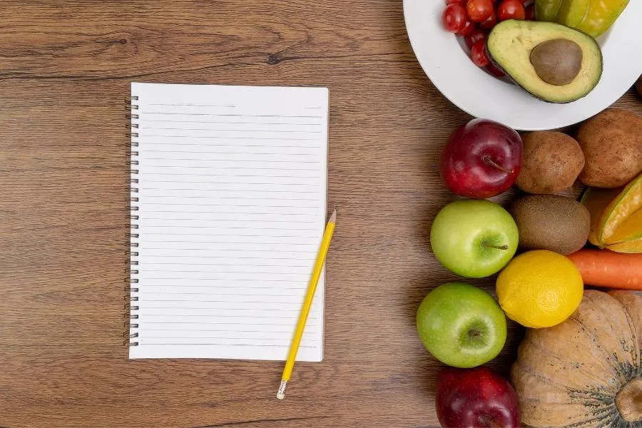 notepad and bowl of fruit