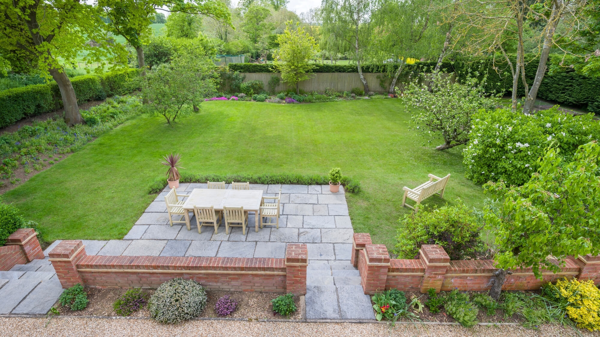 large garden design with terrace, patio, lawn and layered planting