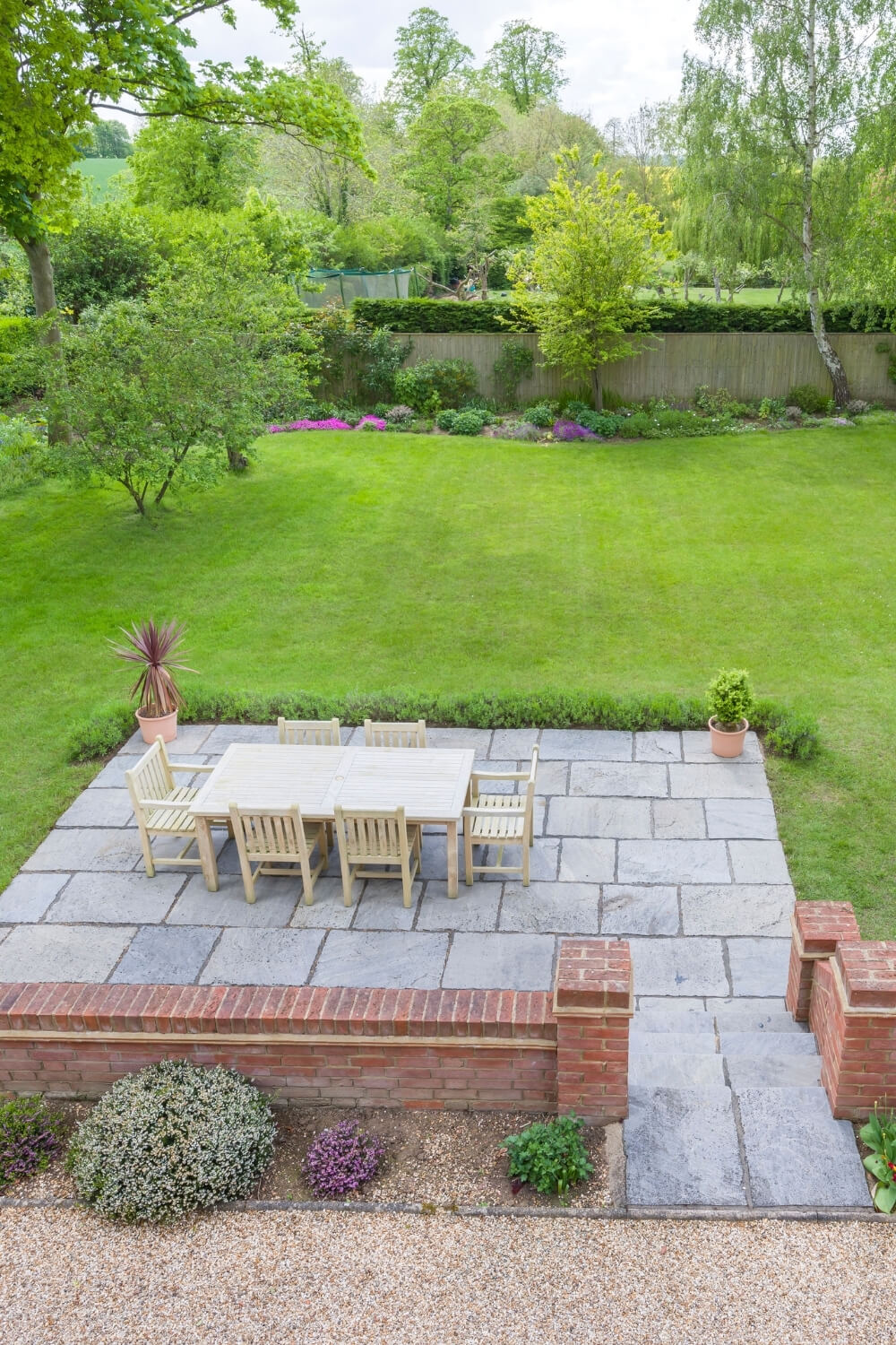 Design-led garden landscaping featuring stone terrace, lawn and planting scheme in a South London family garden