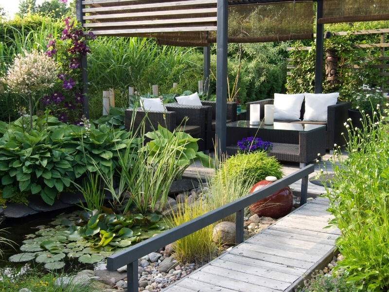 Small garden design in Carshalton with decking, seating, wildlife pond and layered planting