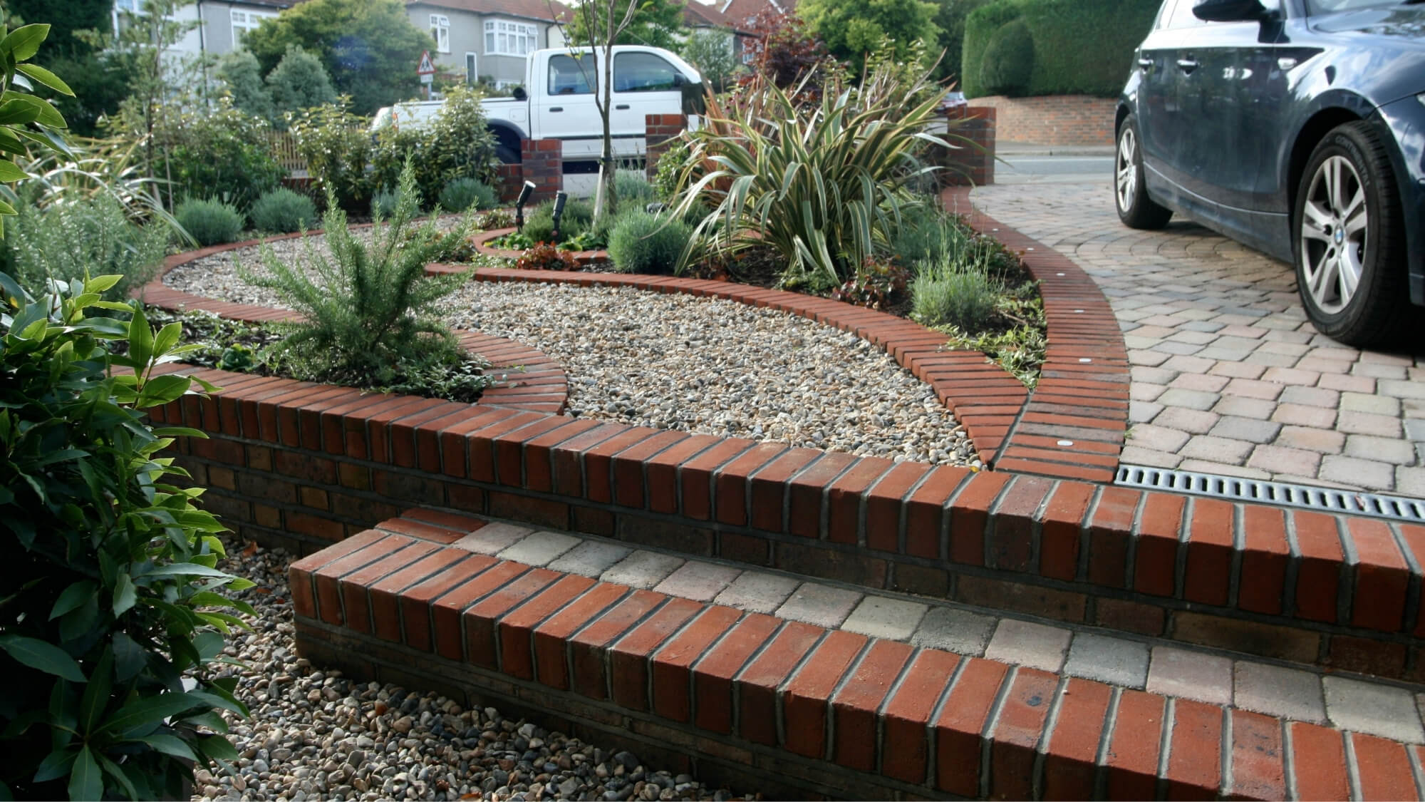 Front garden landscaping in South London with planting beds, driveway lighting and brick steps