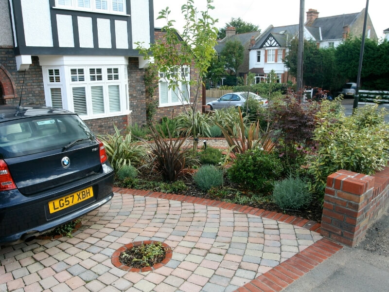 Front garden driveway with circular planting features and evergreen planting borders in South London